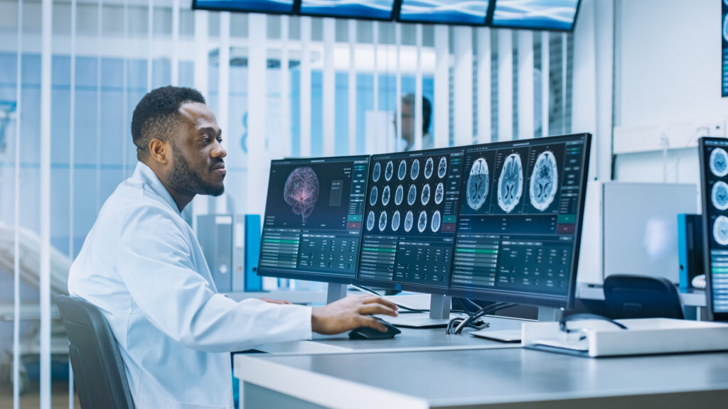 Medical Scientist Working with CT Brain Scan Images on a Personal Computer in Laboratory. Neurologists in Neurological Research Center Working
